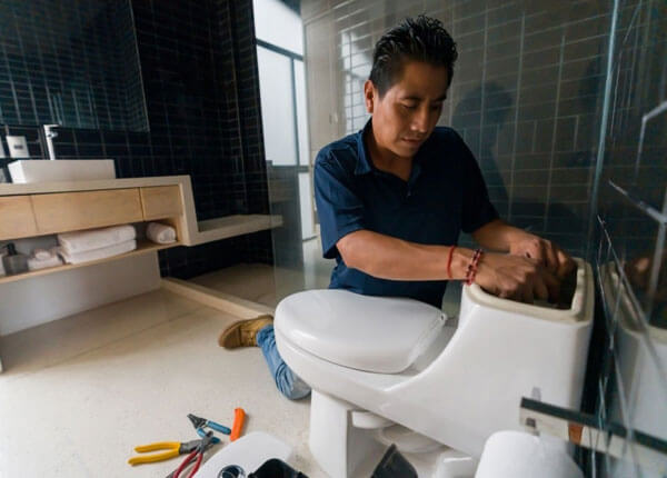 Plumber working on toilet