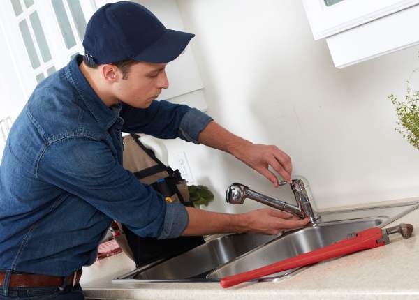 Plumber working on faucet